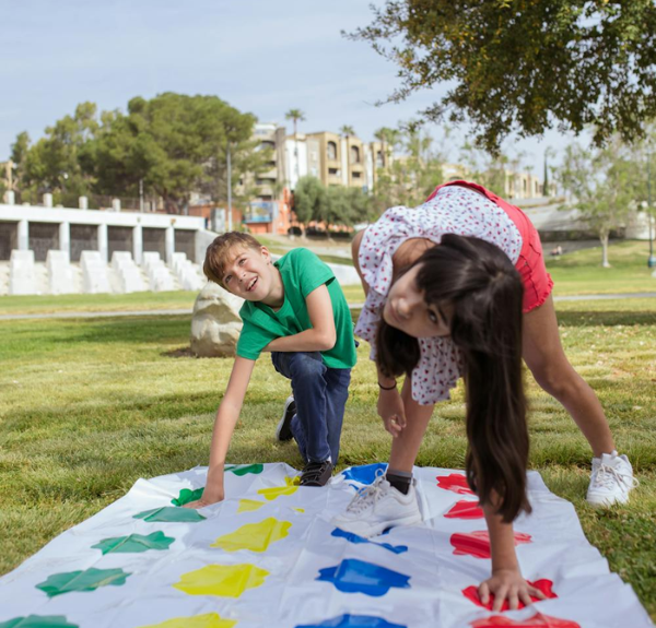 Two school-age children playing outdoors on a school campus.