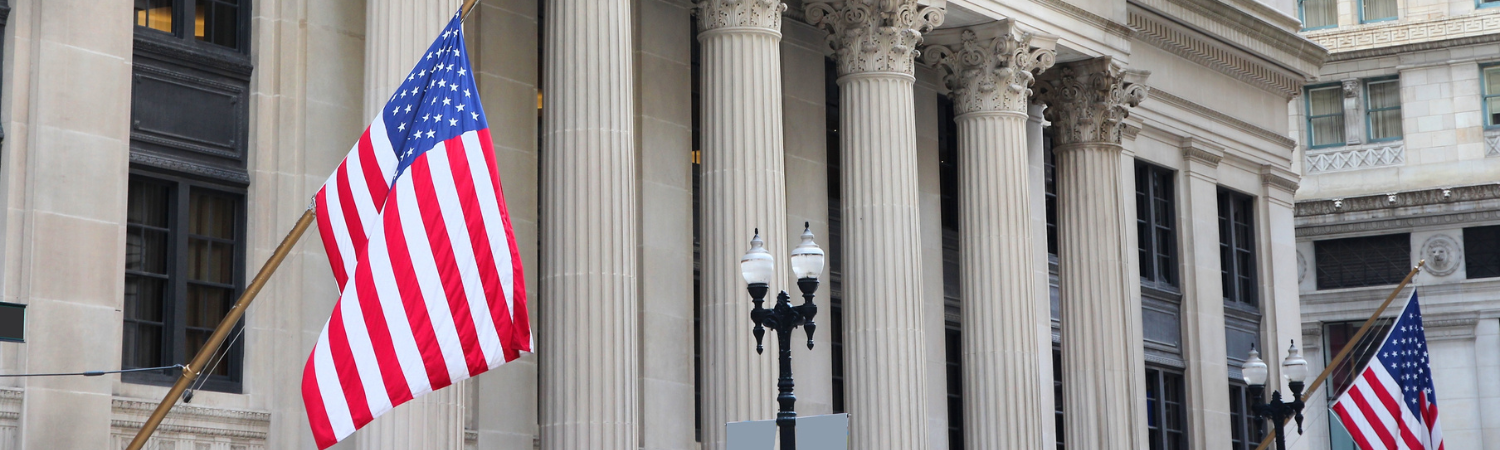 Image of flags in front of a federal building.