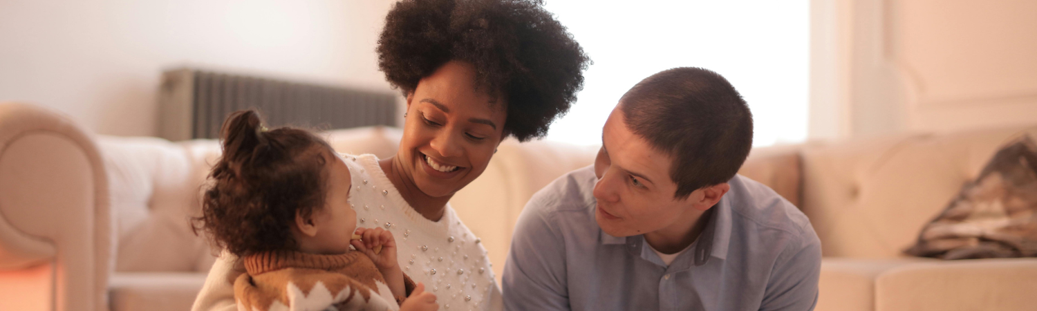 Photo of man and woman having fun with their baby.