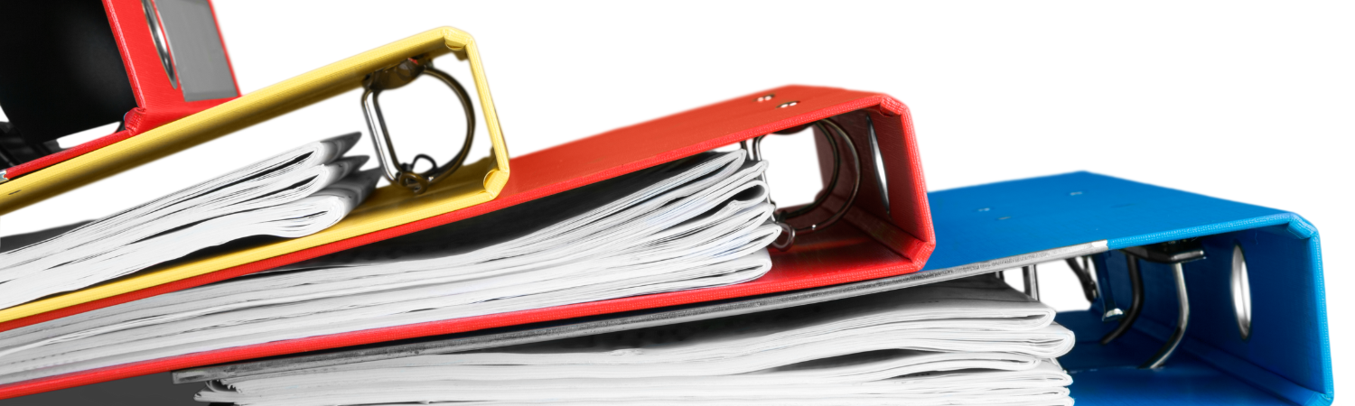 A stack of binders on top of a desk.