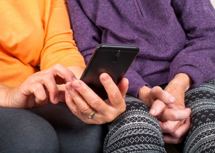 Two people seated and looking at a phone