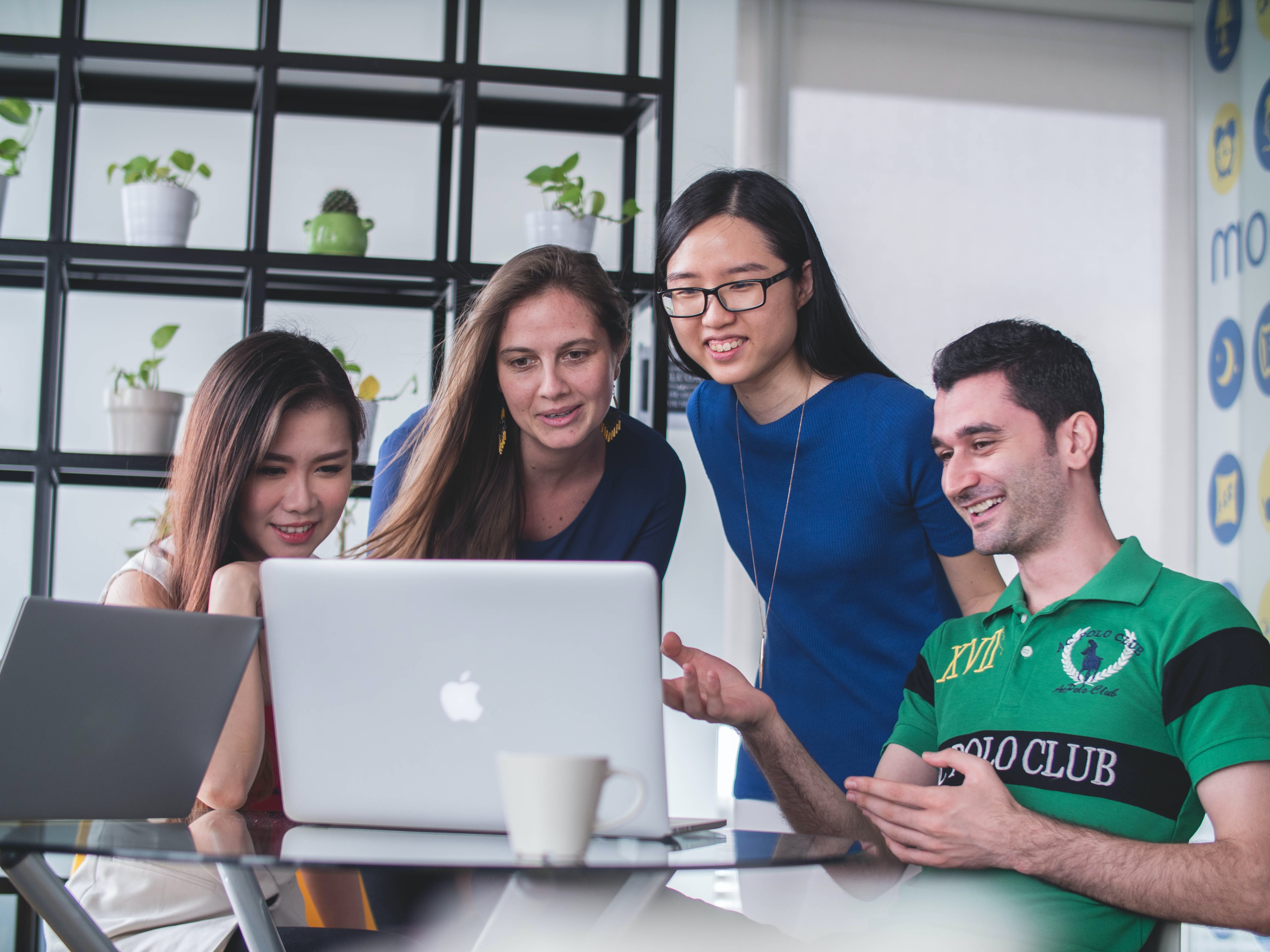 Image of four young employees around a computer.