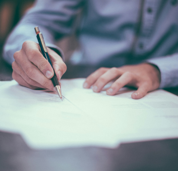 Person writing on a piece of paper.