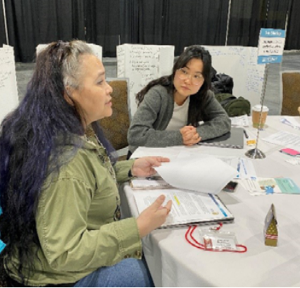 Two woman providing inputs at a table the Bureau of Indian Affairs Alaska Tribal Providers Conference.